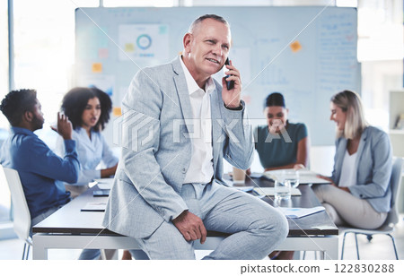 Leadership, phone call and communication while a ceo sit in a meeting with a team of corporate men and women. Workers in at presentation with senior manager while talking on phone in conference room 122830288