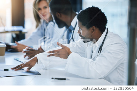 Healthcare, diversity and a medical conference, male doctor in discussion or meeting with team. Teamwork, collaboration and communication, health care workers talking and planning at hospital office. Healthcare, diversity and a medical conference, male doctor in discussion or meeting with team. Teamwork, collaboration and communication, health care workers talking and planning at hospital office. 122830504