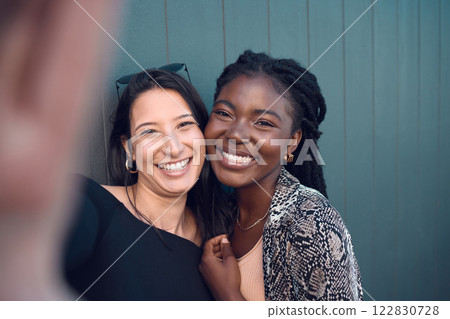 Friends, smile and happy selfie for social media for fashion, street style or trendy clothes women on blue background. Portrait of fun, playing or comic bonding college students for female diversity 122830728