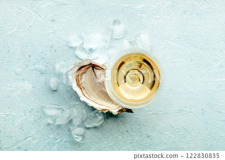 Oyster with a glass of wine, on ice, on a slate background 122830835