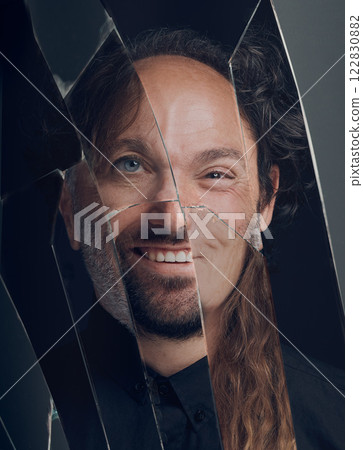 Mental health, personality disorder, schizophrenia or bipolar. Portrait of different horror face in a broken mirror of smile, split or creepy weird smiling expression or reflection on a glass surface 122830882
