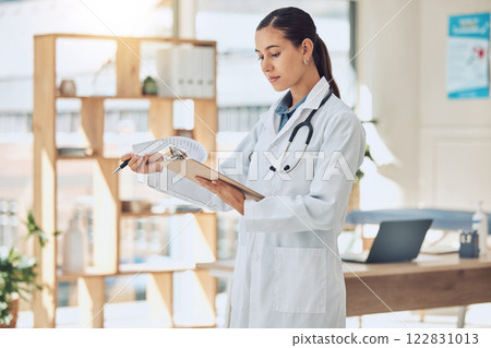 Insurance, healthcare and medicine with a doctor reading paperwork in a clipboard in her office in the hospital. Medical, review and wellness with a female professional in the health industry Insurance, healthcare and medicine with a doctor reading paperwork in a clipboard in her office in the hospital. Medical, review and wellness with a female professional in the health industry 122831013