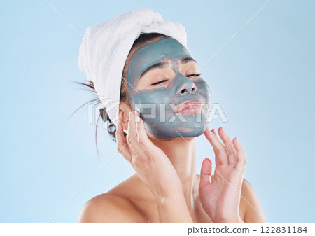 Skincare, body wellness and charcoal face mask for healthy woman skin against blue mockup studio background. Young, happy and beauty cosmetic model with antiaging product for wellbeing and grooming 122831184