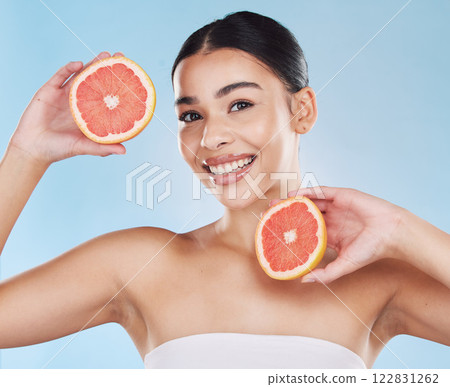 Grapefruit, skincare, face and diet wellness keeps her happy and healthy for skin healthcare, eat healthy fruit with nutrition. Portrait of a beauty woman in studio against a blue background Grapefruit, skincare, face and diet wellness keeps her happy and healthy for skin healthcare, eat healthy fruit with nutrition. Portrait of a beauty woman in studio against a blue background 122831262