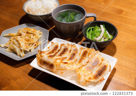 A balanced Japanese-Chinese set meal with fried dumplings and colorful side dishes 122831373
