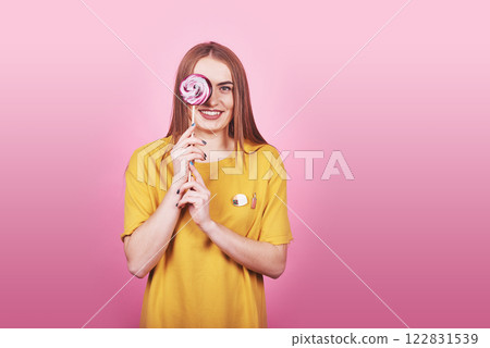 Girl cute funny portrait holding lollipop smiling on pink background. Beautiful multicultural Caucasian girl smiling happy Girl cute funny portrait holding lollipop smiling on pink background. Beautiful multicultural Caucasian girl smiling happy 122831539