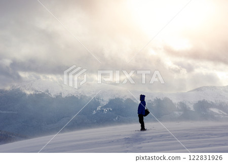 Snowshoe walker running in powder snow with beautiful sunrise light. Outdoor winter activity and healthy lifestyle Snowshoe walker running in powder snow with beautiful sunrise light. Outdoor winter activity and healthy lifestyle 122831926
