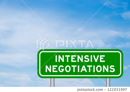 Green color transportation sign with word intensive negotiations on blue sky with white cloud background Green color transportation sign with word intensive negotiations on blue sky with white cloud background 122831997