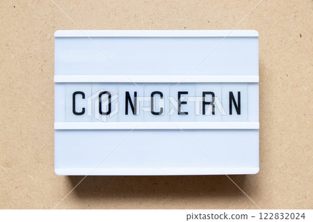 Lightbox with word concern on wood background 122832024