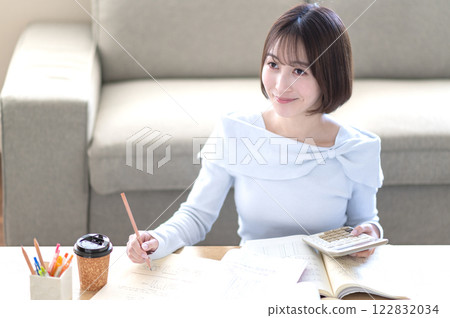 A young woman studying alone in the living room A young woman studying alone in the living room 122832034