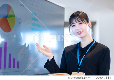 A young businesswoman giving a presentation using a monitor 122832117