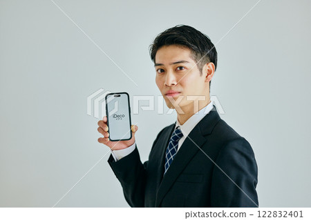 A young man in his twenties holding a smartphone 122832401