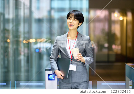 A businesswoman in a suit passing through a security gate. Photo courtesy of Sky Perfect Tokyo Media Center. 122832455