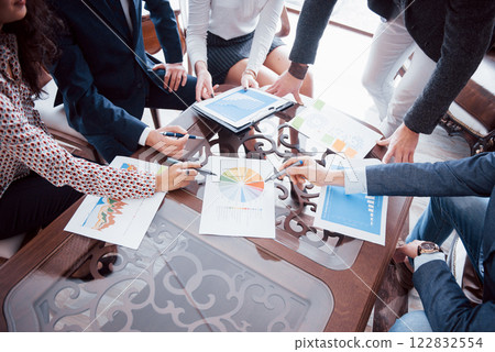 Business team brainstorming. Marketing plan researching. Paperwork on the table, laptop and mobile phone 122832554