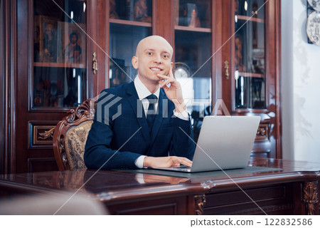 Confident handsome businessman sitting in luxury interior 122832586