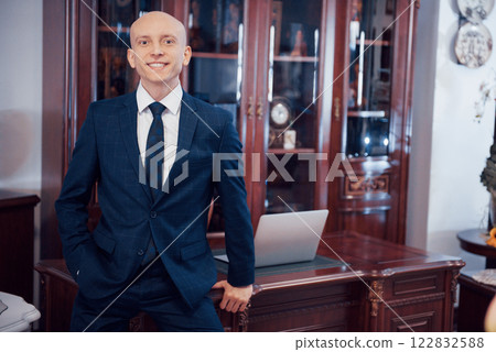 Confident handsome businessman sitting in luxury interior 122832588