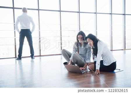 Young creative people in modern office. Group of young business people are working together with laptop. Freelancers sitting on the floor. Cooperation corporate achievement. Teamwork concept 122832615
