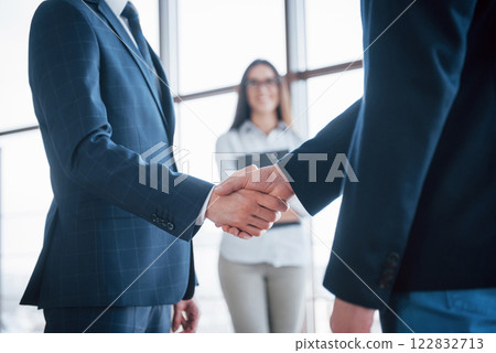 Two confident business man shaking hands during a meeting in the office, success, dealing, greeting and partner concept 122832713