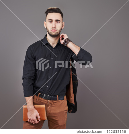 Portrait of toothy handsome bearded man with book on hands Portrait of toothy handsome bearded man with book on hands 122833136