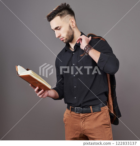 Portrait of toothy handsome bearded man with book on hands 122833137