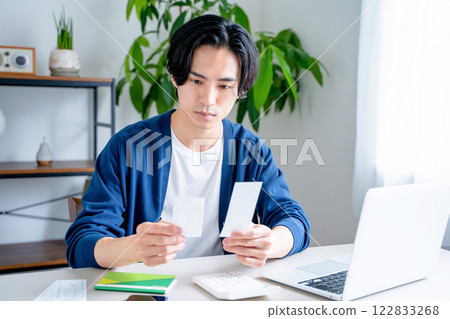 一個男人看著他的銀行存摺 122833268