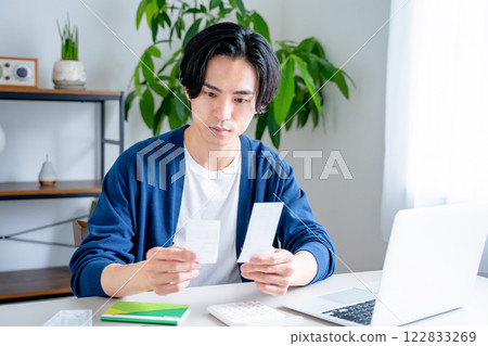 一個男人看著他的銀行存摺 122833269