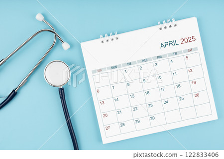 April 2025 desk calendar and stethoscope on blue, Medical appointment concept. 122833406