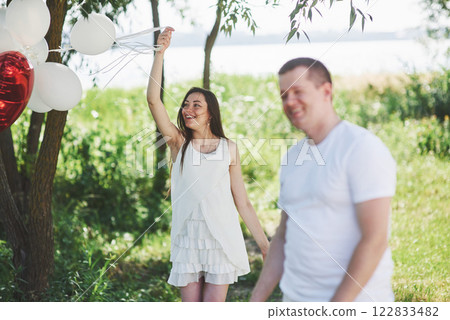 Happy and young pregnant couple hugging in nature. Romantic moments 122833482