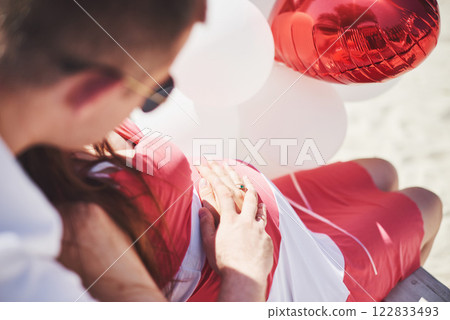 waiting baby. pregnant woman with beloved husband sit on a bench. Husband hand embraces a round belly wife. Parenthood. pregnant woman in a white dress in cherry with a red bow. close-up. nine months waiting baby. pregnant woman with beloved husband sit on a bench. Husband hand embraces a round belly wife. Parenthood. pregnant woman in a white dress in cherry with a red bow. close-up. nine months 122833493