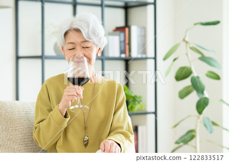 Senior woman drinking wine in the living room 122833517