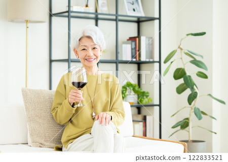 Senior woman drinking wine in the living room 122833521