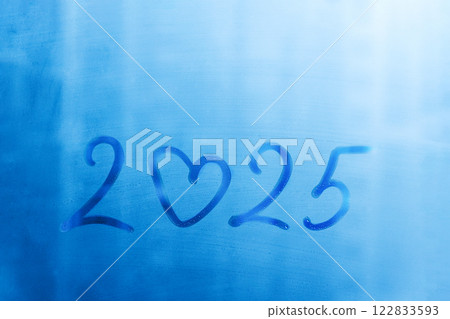 numbers 2025 of new year with doodling heart shape paint on splashed by rain foggy blue glass on window 122833593