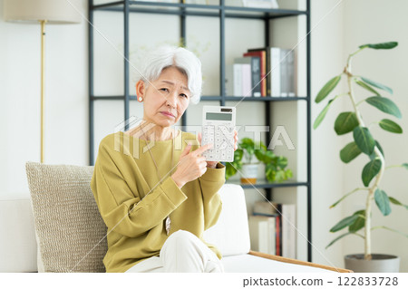 Senior woman with calculator 122833728