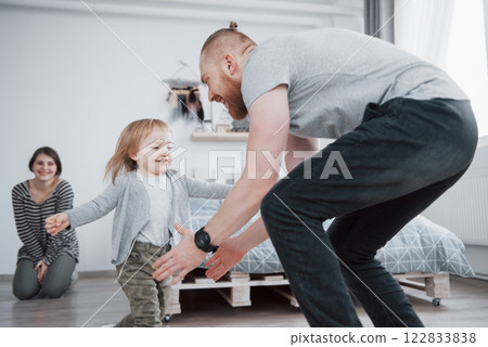 happy family is having fun at home. Mother, father and little daughter with plush toy are enjoying being together 122833838