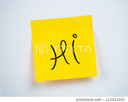 A bright yellow sticky note displays the word hi in a playful font 122833891