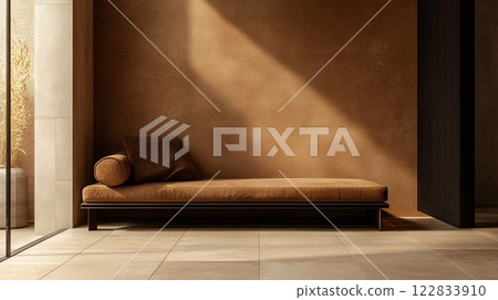 Tan couch is sitting in front of a tan wall. The couch is empty and the room is very simple 122833910