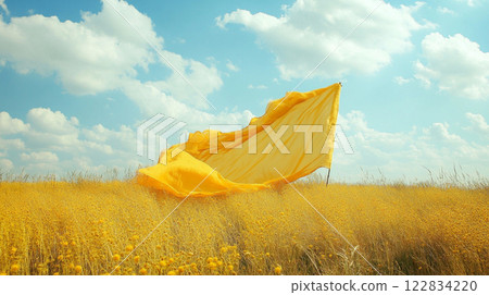 Yellow flag is flying in the sky over a field of yellow flowers. The flag is large and has a lot of space around it, giving the impression of a vast, open field Yellow flag is flying in the sky over a field of yellow flowers. The flag is large and has a lot of space around it, giving the impression of a vast, open field 122834220