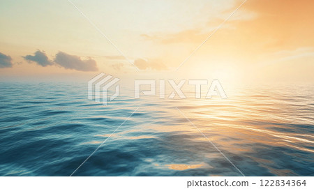The ocean is calm and the sky is a beautiful orange color. The sun is setting, casting a warm glow over the water 122834364