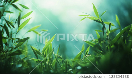 Beautiful, lush green field with many leaves scattered throughout. The sky above is a bright blue, creating a serene and peaceful atmosphere. The leaves are of various sizes and shapes 122834388