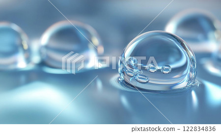 Close up of a clear sphere of water. The sphere is surrounded by a blue background. The sphere is the main focus of the image 122834836