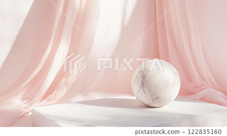 White marble sits on a pedestal in front of a curtain. The scene is simple and elegant, with the marble as the focal point 122835160