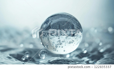 Clear sphere of water is floating on the surface of a body of water. The water is calm and still, with no ripples or waves. The sphere is the only object in the image 122835337