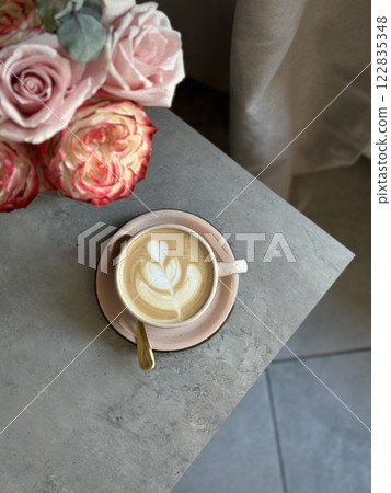 L.atte art tulip flower beautiful. Coffee cup cappuccino and a bouquet of flowers. Hygge lifestyle, cozy mood. Coffee, flower in back light. 122835348
