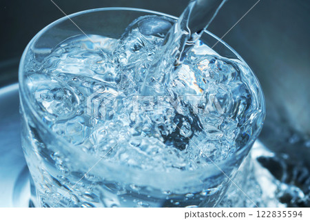Water being poured vigorously into a glass Water being poured vigorously into a glass 122835594