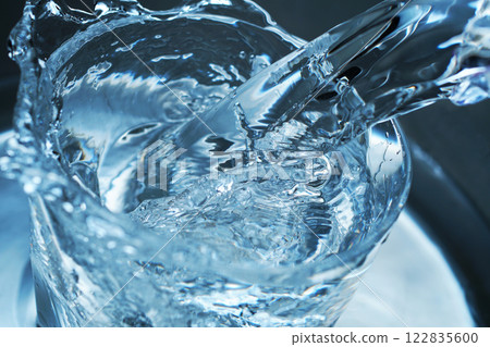 Water being poured vigorously into a glass Water being poured vigorously into a glass 122835600