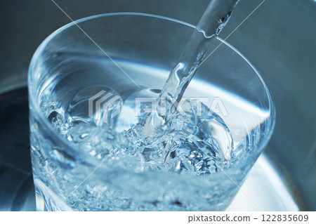 Water being poured vigorously into a glass Water being poured vigorously into a glass 122835609