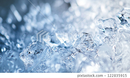 Close up of ice cubes in a glass of water. The ice cubes are scattered throughout the glass, creating a sense of movement and fluidity. The image conveys a feeling of coldness and refreshment 122835915