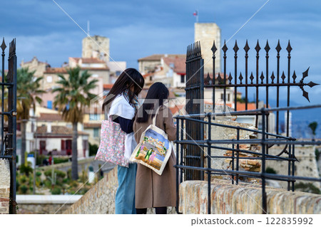 Tourist women at Antibes castle and central square, palm and cactus garden by the sea 122835992