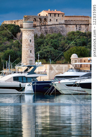 Antibes castle and port with boats and tower over blue sky Antibes castle and port with boats and tower over blue sky 122835995