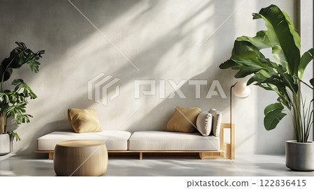 Living room with a white couch and two potted plants. The couch is covered in pillows and the plants are placed on the floor. The room has a modern and minimalist design 122836415